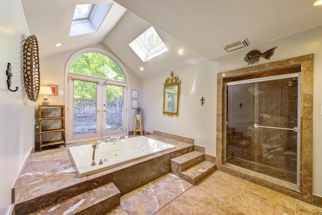 full bathroom featuring visible vents, a jetted tub, vaulted ceiling with skylight, french doors, and a stall shower