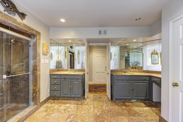 bathroom with visible vents, a stall shower, and a sink