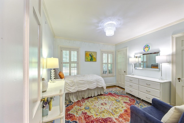 bedroom with baseboards, wood finished floors, and crown molding