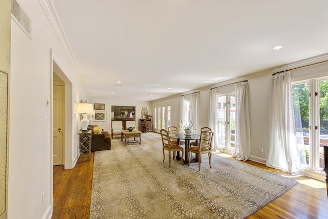 dining room featuring visible vents, a healthy amount of sunlight, and wood finished floors