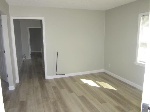 spare room with light wood-type flooring and baseboards