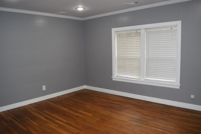 spare room featuring visible vents, dark wood-style floors, baseboards, and ornamental molding