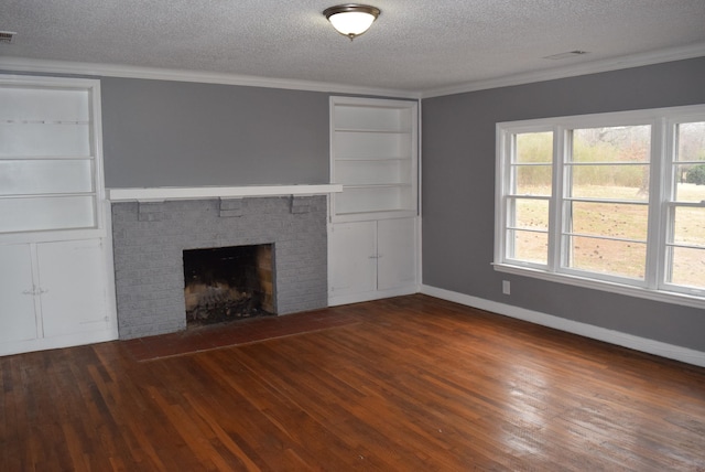 unfurnished living room with a brick fireplace, a textured ceiling, crown molding, and wood-type flooring