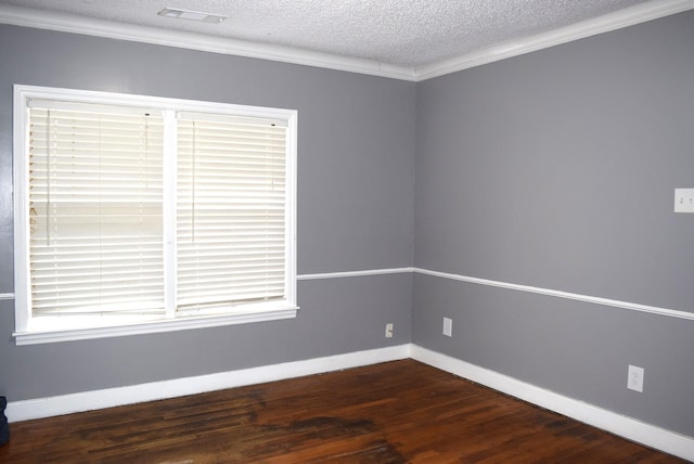 unfurnished room with visible vents, a textured ceiling, dark wood-style floors, crown molding, and baseboards