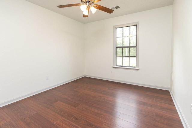 spare room with visible vents, baseboards, ceiling fan, and dark wood-style flooring