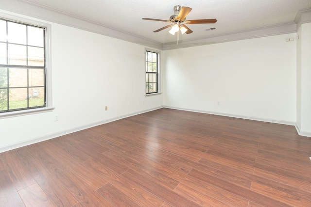 unfurnished room featuring visible vents, wood finished floors, and ornamental molding