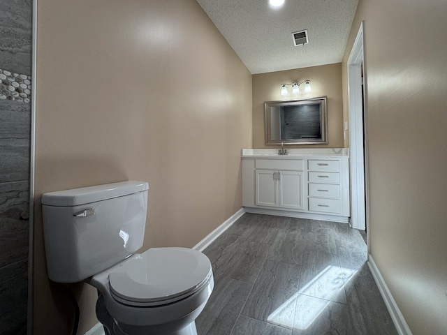 bathroom featuring vanity, baseboards, visible vents, a textured ceiling, and toilet