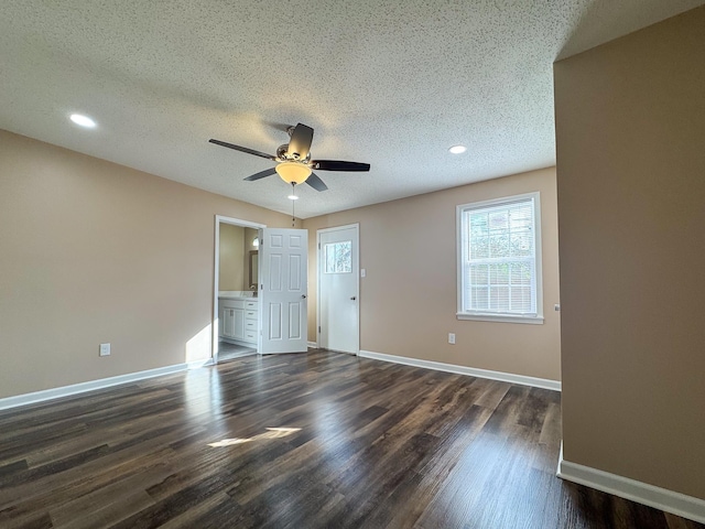 interior space featuring dark wood finished floors, ceiling fan, a textured ceiling, and baseboards