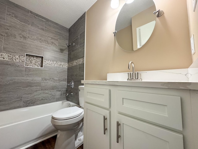 bathroom featuring washtub / shower combination, toilet, vanity, and a textured ceiling