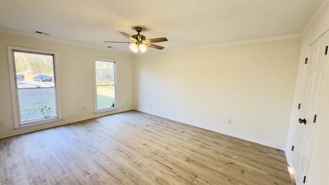 unfurnished room featuring light wood-type flooring, visible vents, ornamental molding, baseboards, and ceiling fan