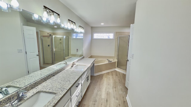 full bath with a sink, a garden tub, a stall shower, and double vanity