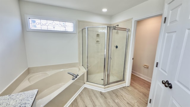 full bath featuring recessed lighting, wood finished floors, a garden tub, and a stall shower