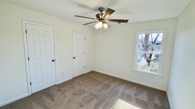 unfurnished bedroom featuring baseboards, carpet floors, and ceiling fan