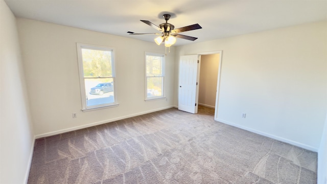 carpeted empty room with baseboards and ceiling fan