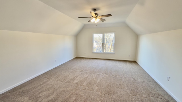 additional living space featuring carpet, vaulted ceiling, a ceiling fan, and baseboards