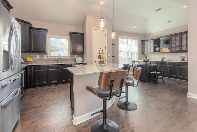 kitchen featuring visible vents, lofted ceiling, plenty of natural light, and stainless steel fridge with ice dispenser