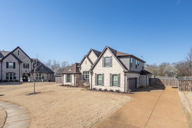 view of front of home featuring brick siding, concrete driveway, an attached garage, and fence