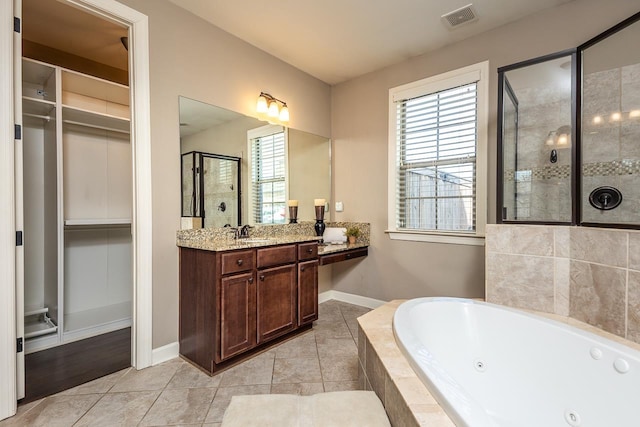 bathroom with visible vents, a stall shower, a whirlpool tub, a spacious closet, and vanity