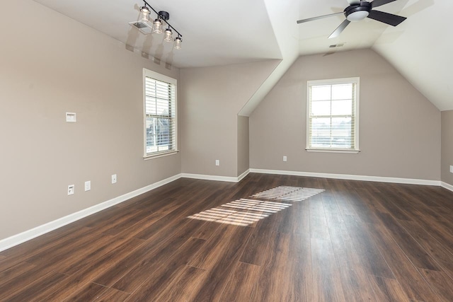 additional living space with a healthy amount of sunlight, dark wood-style flooring, and baseboards