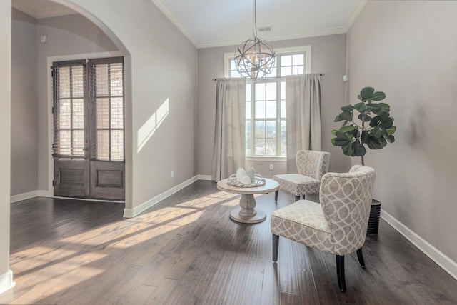 sitting room featuring crown molding, wood finished floors, arched walkways, and a healthy amount of sunlight