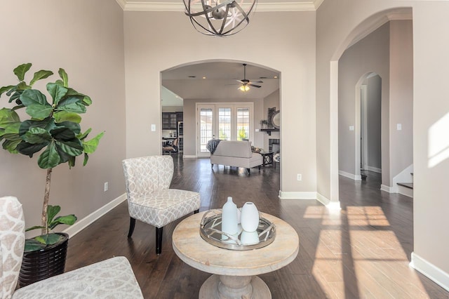 interior space with crown molding, wood finished floors, and arched walkways