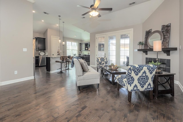 living room with visible vents, a fireplace, a ceiling fan, and dark wood-style flooring