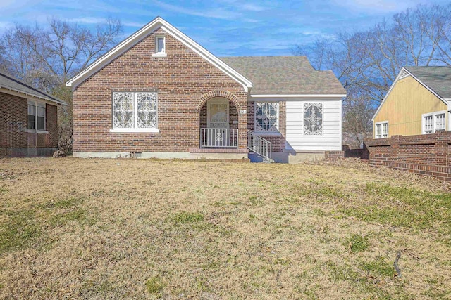 view of front of house featuring brick siding and a front lawn