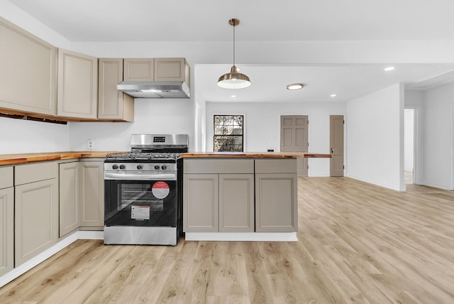 kitchen with under cabinet range hood, butcher block counters, recessed lighting, light wood-style floors, and stainless steel gas stove