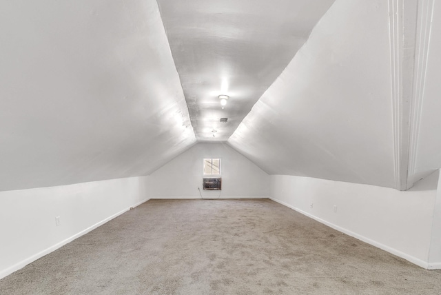 additional living space featuring baseboards, lofted ceiling, and carpet