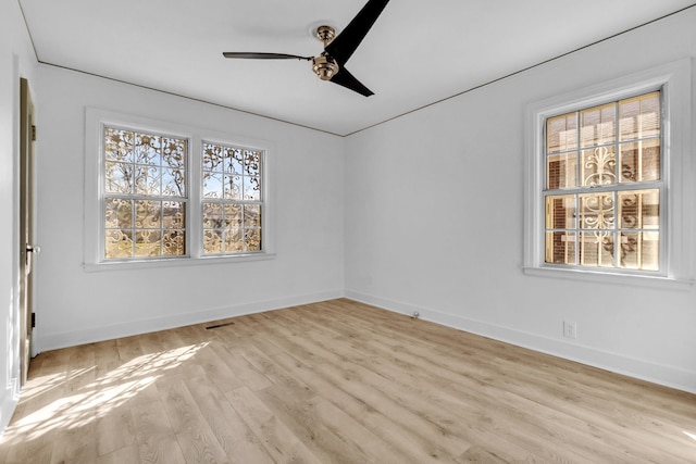 empty room with baseboards, light wood-type flooring, and a ceiling fan