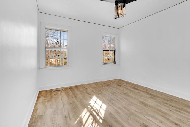 unfurnished room with visible vents, baseboards, and wood finished floors