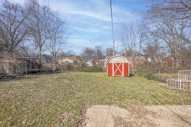 view of yard with a storage shed, an outbuilding, and fence