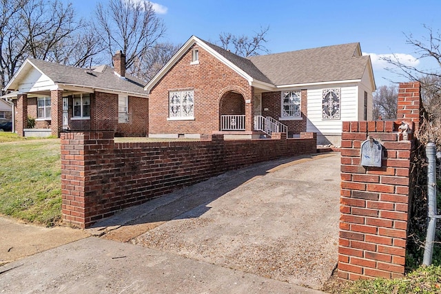 view of front of property with brick siding, aphalt driveway, and roof with shingles