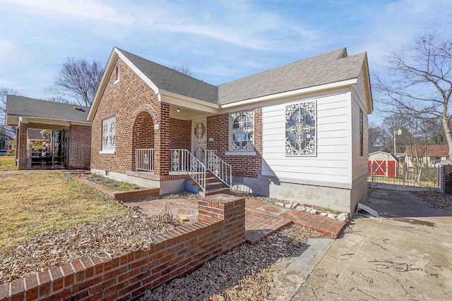 view of front of home featuring brick siding and a shingled roof