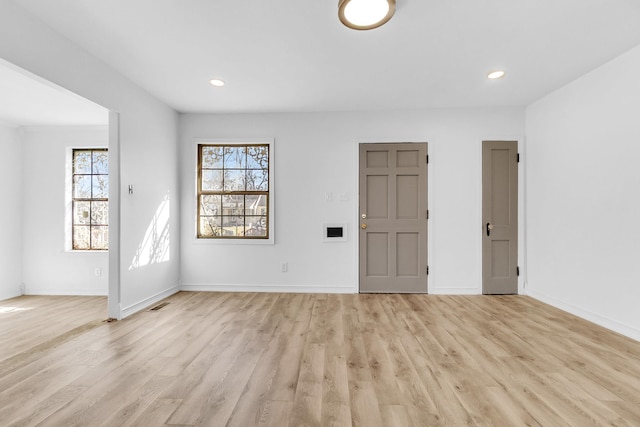 unfurnished room with visible vents, a healthy amount of sunlight, and light wood-style flooring