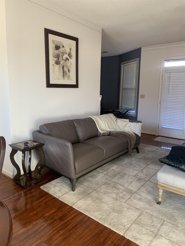 living room featuring crown molding, wood finished floors, and baseboards