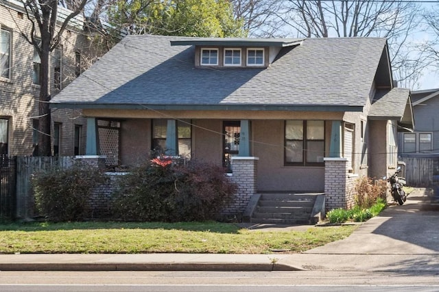 view of front facade featuring stucco siding, brick siding, and roof with shingles