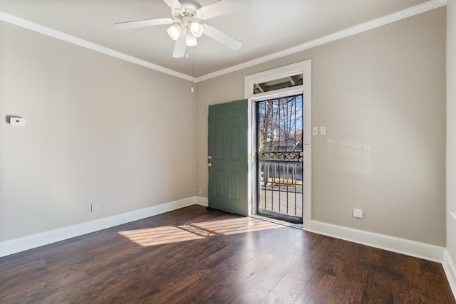 spare room with baseboards, wood finished floors, and ornamental molding