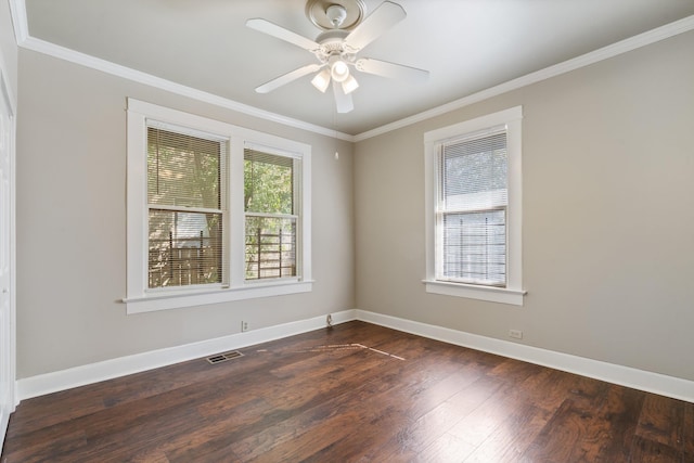 empty room featuring visible vents, baseboards, ornamental molding, and dark wood-style flooring