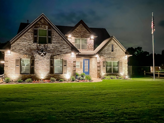 craftsman house featuring a lawn and stone siding