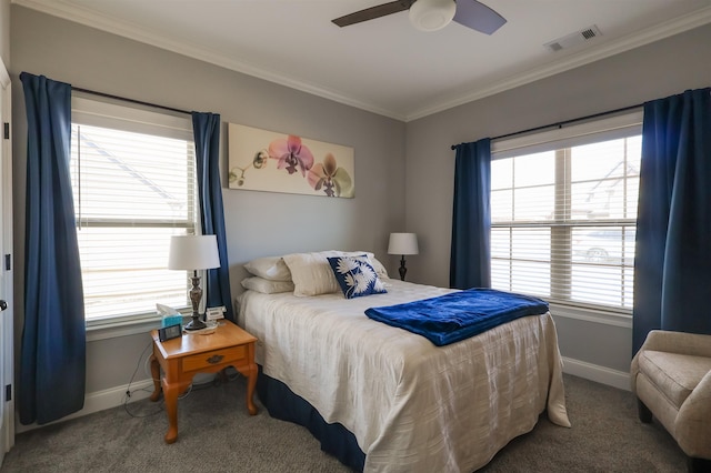carpeted bedroom featuring visible vents, baseboards, ornamental molding, and a ceiling fan