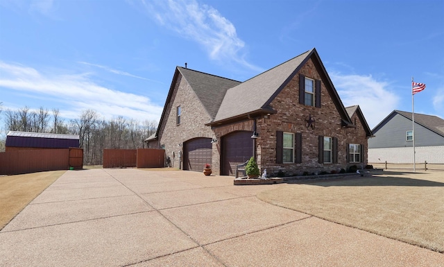 view of side of home with brick siding, a shingled roof, fence, concrete driveway, and an attached garage