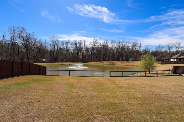 view of yard with a water view and fence