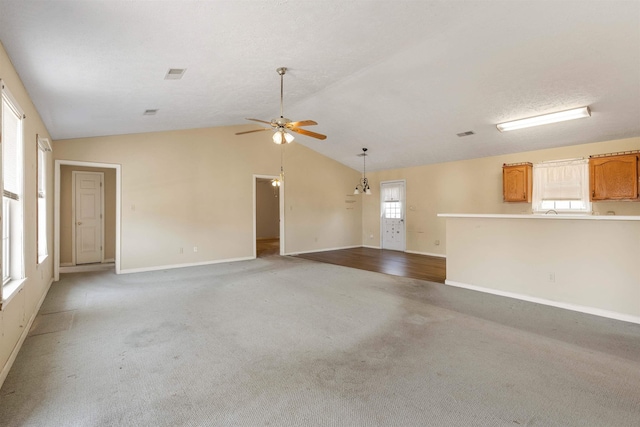 empty room featuring baseboards, visible vents, ceiling fan, vaulted ceiling, and light colored carpet