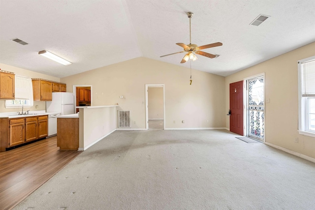 unfurnished living room featuring visible vents, a ceiling fan, and vaulted ceiling