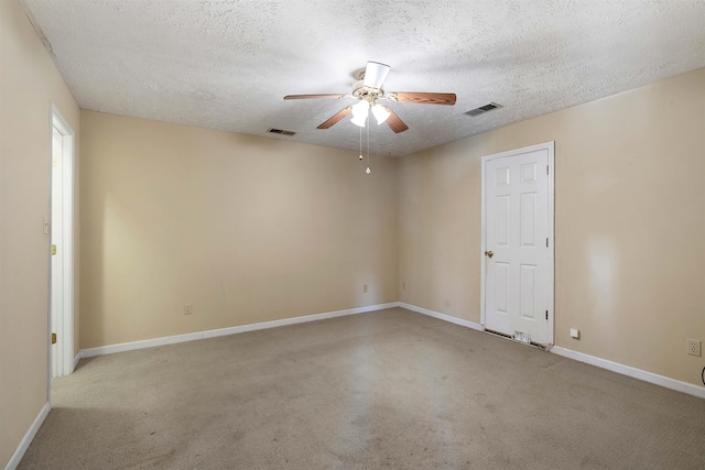 carpeted spare room featuring visible vents, a textured ceiling, baseboards, and ceiling fan