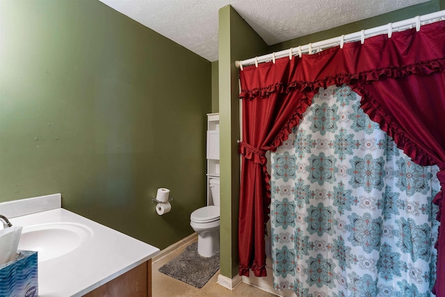 full bathroom featuring toilet, curtained shower, a textured ceiling, and vanity