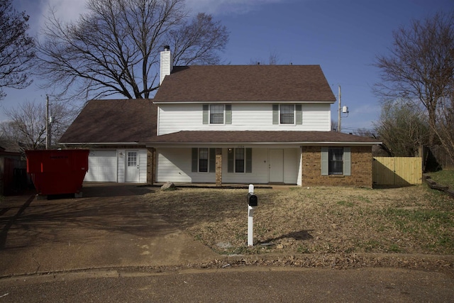 view of front facade featuring an attached garage, fence, covered porch, a chimney, and driveway