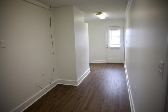 hallway with dark wood finished floors and baseboards