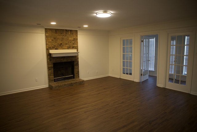 unfurnished living room with recessed lighting, baseboards, dark wood-style floors, and a fireplace